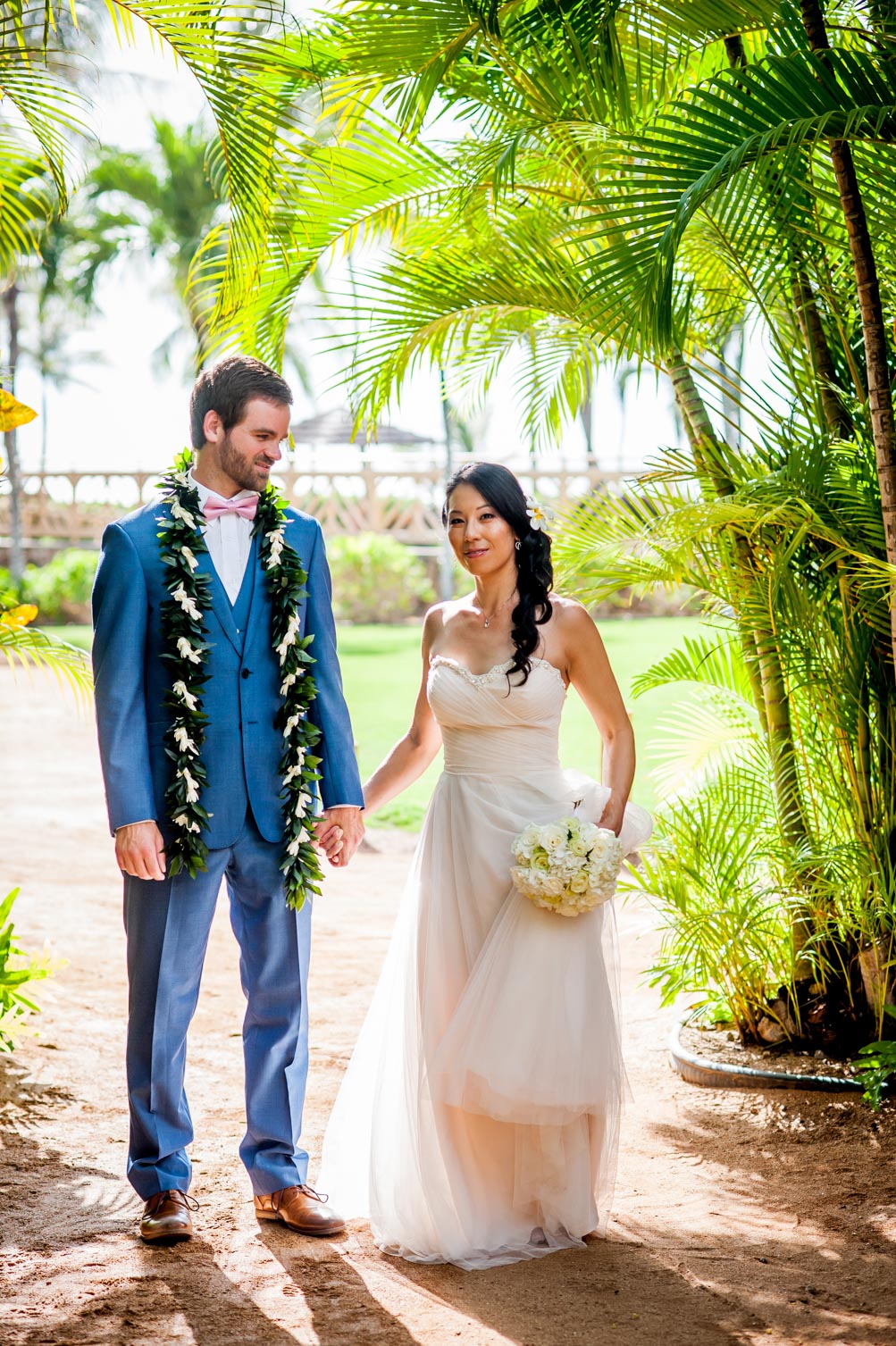 Hawaii wedding couple holding hands in lush greenery
