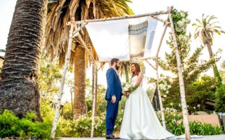 Jewish wedding couple under the chuppah with palm trees