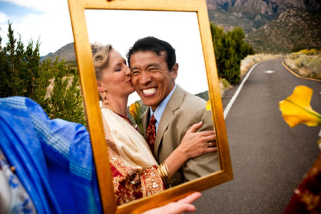 Tibetan groom smiling in mirror reflection on wedding day